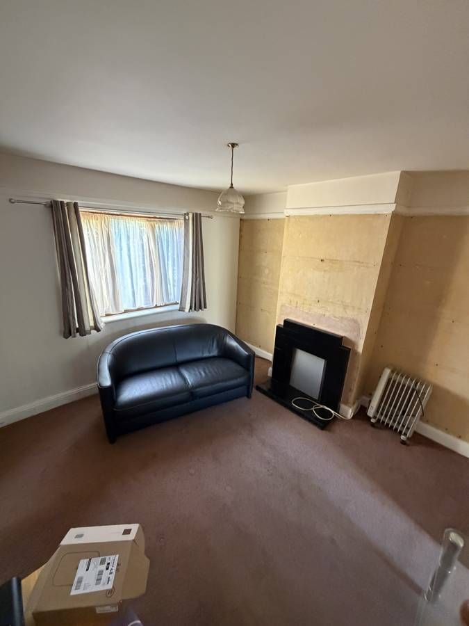 Before: worn carpet, a 1950s fire surround and walls hidden behind paper.