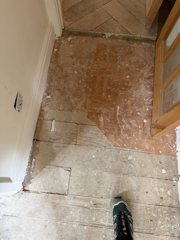 Front hall: patched and woodworm-affected boards.